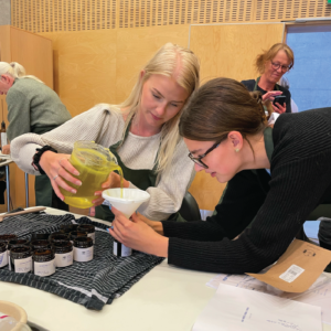 Til kvinder, der eksperimenterer med urter ved et arrangement på en urteskole, hvor de lærer om og arbejder med planter.